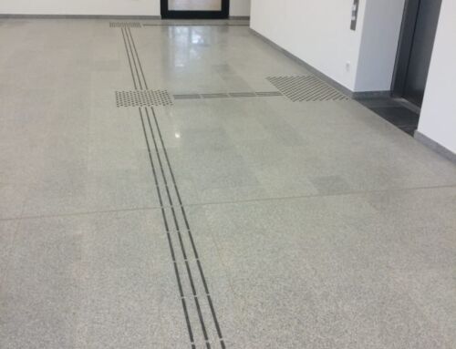 Barrierefreier Flurbereich mit Naturstein und taktilen Leitlinien